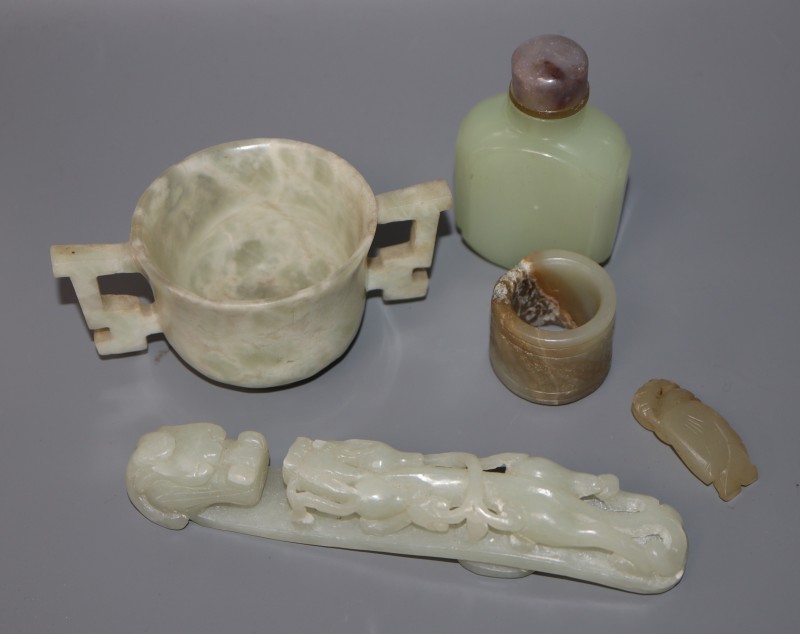 A Chinese jade belt hook, an archers ring and figure, a stone cup and a glass snuff bottle